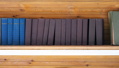 Wooden shelf with old books. Stack of books in the library, panoramic view. Cultural heritage