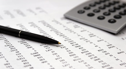 Financial accounting, Image a plurality of numbers on paper and calculator, Numbers on paper, a pen and a calculator.