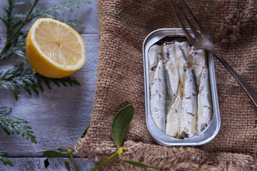 Can of sardines with lemon and rustic background