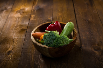 fresh vegetables in a wooden bowel on the table