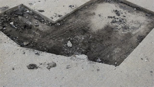 Road works are carried out on the asphalt section. Cracks and wrong operation of roads has resulted in potholes and patching. Outdoor, microcracks, pits, patches, daytime, real time, natural light, on