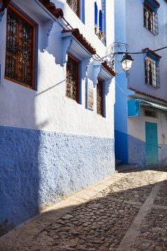 sun light throw narrow street in blue city Chefchaouen in Morocco