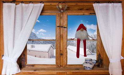 Christmas card with snowy landscape behind a window of a mountain house