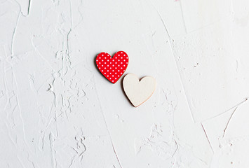 Two wooden decorative hearts on white
