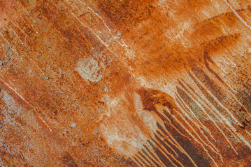 painted iron surface with a large rusty and metal corrosion, old background with peeling and cracking paint as background, orange texture