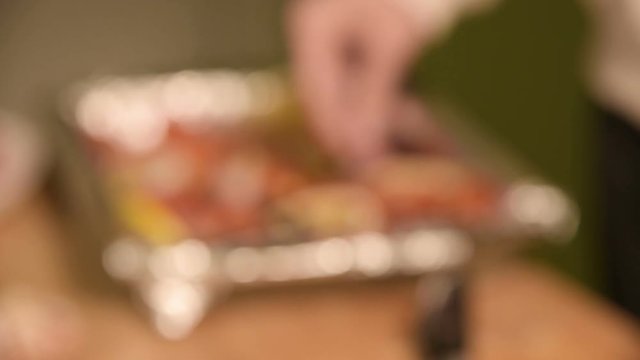 Closeup of the hands of a girl at the home kitchen on a wooden cutting board small cherry tomatoes. Home cooking