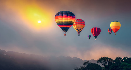 Hot air balloons flying above high mountain at sunrise at Dot Inthanon in Chiang Mai, Thailand.  Filtered image: Cross processed vintage effect