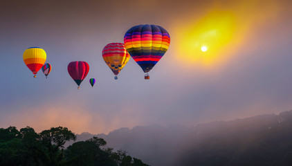 Hot air balloons flying above high mountain at sunrise at Dot Inthanon in Chiang Mai, Thailand.