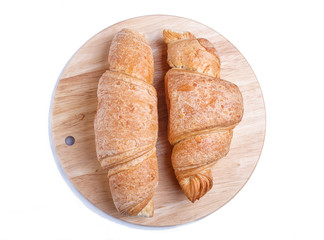 two croissants on wooden kitchen board isolated on white background