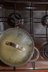 The pan is made of metal standing on a gas stove