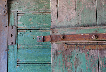 Old colorful paint peeling on a vintage rustic wooden door