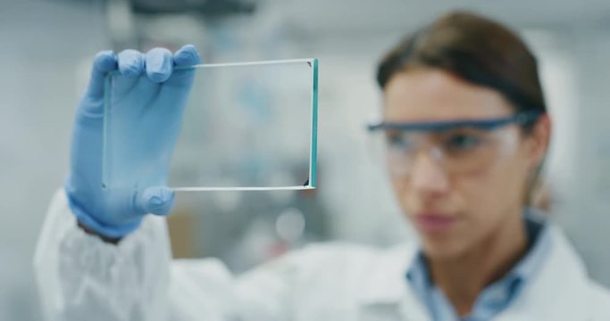 Portrait of futuristic researcher using the augmented reality screen with hologram graphics for viewing results of his research in laboratory. Shot in 8K. Concept of futuristic medicine and science