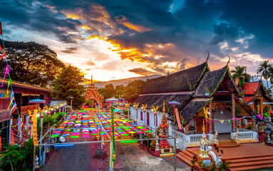 Colorful umbrellas and Thai Temple with sunset sky, Northern Thai Style Lanterns at Loi Krathong (Yi Peng) Festival, Chiang Mai, Thailand. - obrazy, fototapety, plakaty