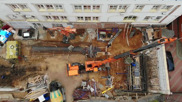 Aerial view from a great height above the crane of a building site, erection of a wall by pouring concrete, monolithic wall technology. made with drone - video