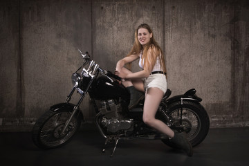 Fototapeta na wymiar Beautiful biker girl on a motorcycle