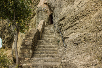 Fototapeta na wymiar enter to dungeon in stone cave in rock with stairs path way