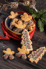 Christmas holiday background with gingerbread cookies, candy canes and evergreens over wooden table. Christmas and New year food. Christmas decoration and sweets on wood background.