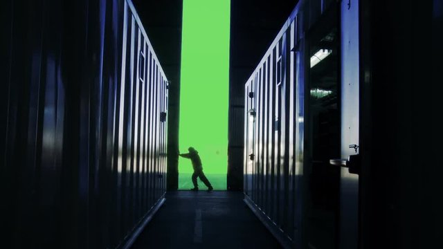 Man Opening Door of a Container Warehouse With Green Screen Background. You can replace green screen with the footage or picture you want with “Keying” effect in AE  (check out tutorials).