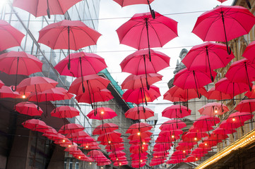 red umbrellas hanging from wires
