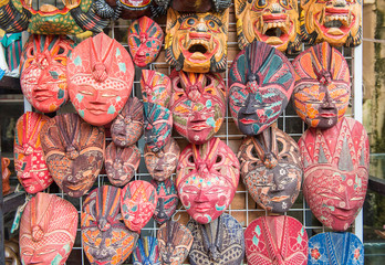 Group of traditional Bali Batik mask hanging for souvenir sell in Ubud market, Bali island of...