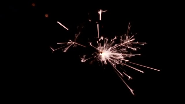 slow motion sparkler burning against black background