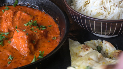 Chicken Tikka Masala. Indian Cast Iron Curry Dish Served with Basmati Rice and Naan