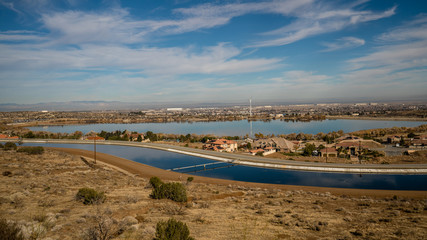 The California aqueduct near Palmdale California running water to Los Angeles California. A small reservoir is behind the canal. This area is right on top of the San Andreas earthquake fault. 