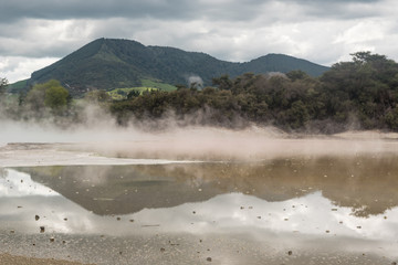 Reflections on the calm surface of the Artist's Palette at the Wai-O-Tapu geothermal area near Rotorua, New Zealand.