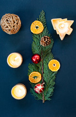 flat lay of christmas arrangement with candles  oranges  decorations on fir branch