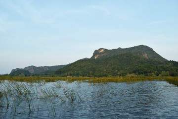 Rock cliff and green forest on limestone mountain on the vast wetland at Khao Sam Roi Yot National Park , Thailand 