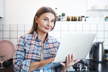 Age, electronic gadgets, lifestyle and technology concept. Positive friendly looking modern woman...