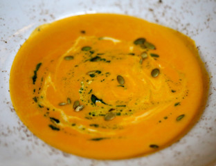 Photo macro fresh soup of pumpkin puree on milk