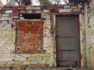 a window and the door of a house that is not inhabited anymore