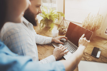 Happy young man and woman working on laptop