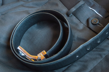 A black leather belt kept on a formal pant trouser