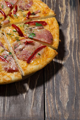 pizza with sausage on a wooden table, vertical
