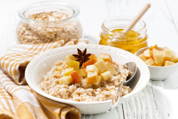 plate of oatmeal with apples on white table