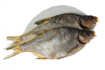 Two dried bream on a white dish. Isolated on white,