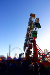 Fototapeta na wymiar Miniature tilt shift image of thrill rides on the midway at the San Diego County fair
