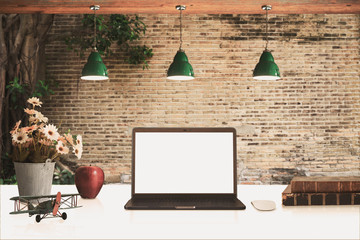Loft workspace with mockup laptop on desk