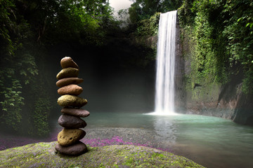 Stacked stones in beautiful relaxing scenic tropical waterfall, peace and tranquility