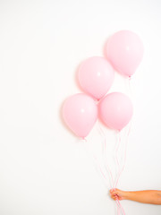 Female hand holding pink balloons