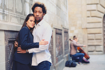 Una pareja feliz y enamorada interracial en las calles de Barcelona pasando un día bonito.
