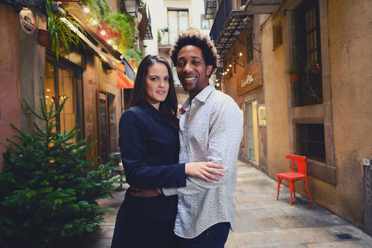 Una pareja feliz y enamorada interracial en las calles de Barcelona pasando un d&iacute;a bonito.