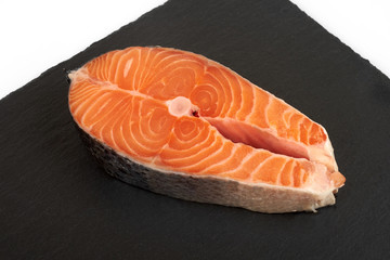 fresh salmon steak on a slate plate , isolated on a white background.