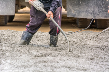 Construction worker pouring cement for doing the road.