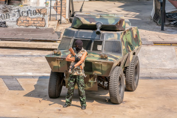 Fototapeta premium Man holding rifle while standing against tank