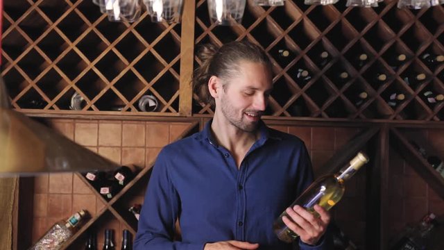 Smiling Man With Bottle Of Wine In Cellar At Winery Restaurant