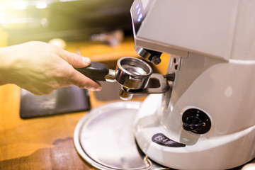 Close up Freshly coffee powder in coffee holder from coffee maker machine Grinder