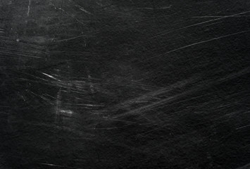 Old black stucco wall with white scratches and scuffs texture. textured grunge black board with...